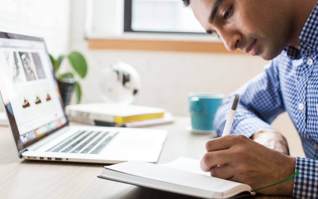 Man writing personal goals in journal