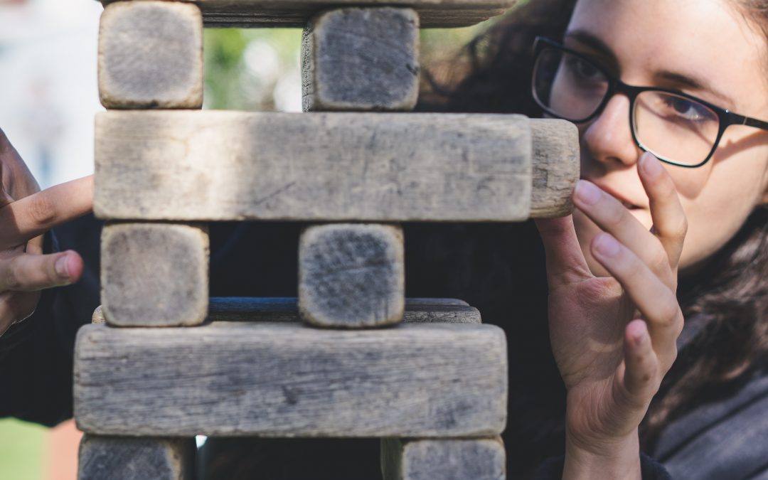woman evaluating risk while playing with blocks